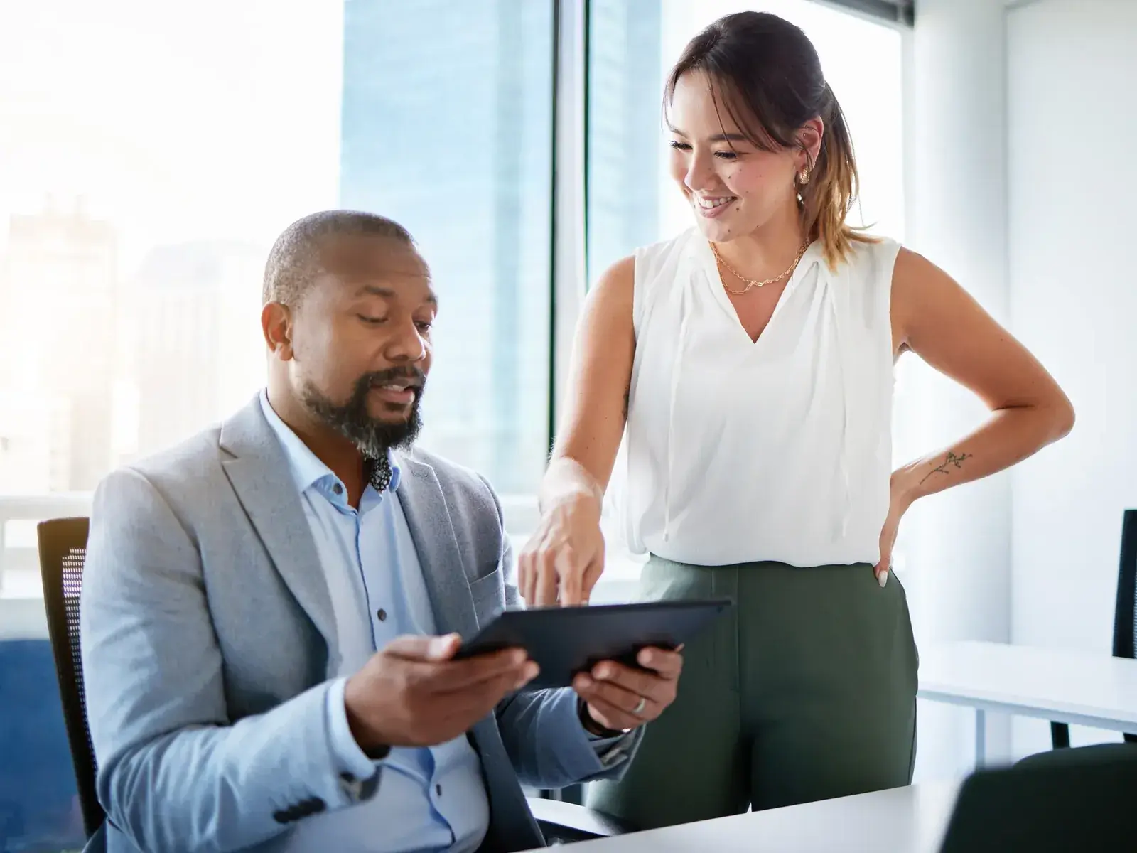 HR-manager en directielid bekijken samen de cijfers op een tablet