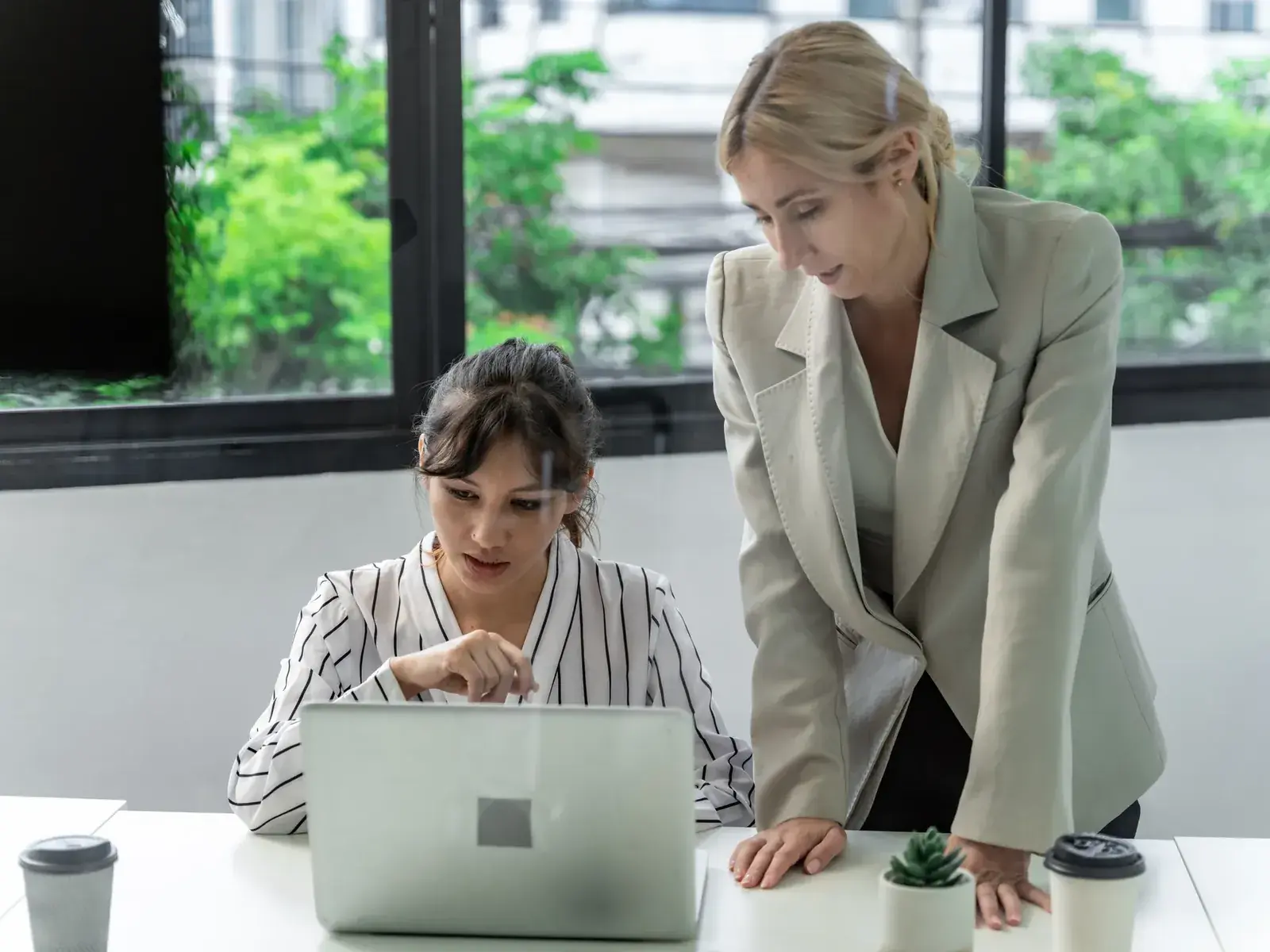 Twee HR-collega’s volgen samen een softwaredemo achter een laptop