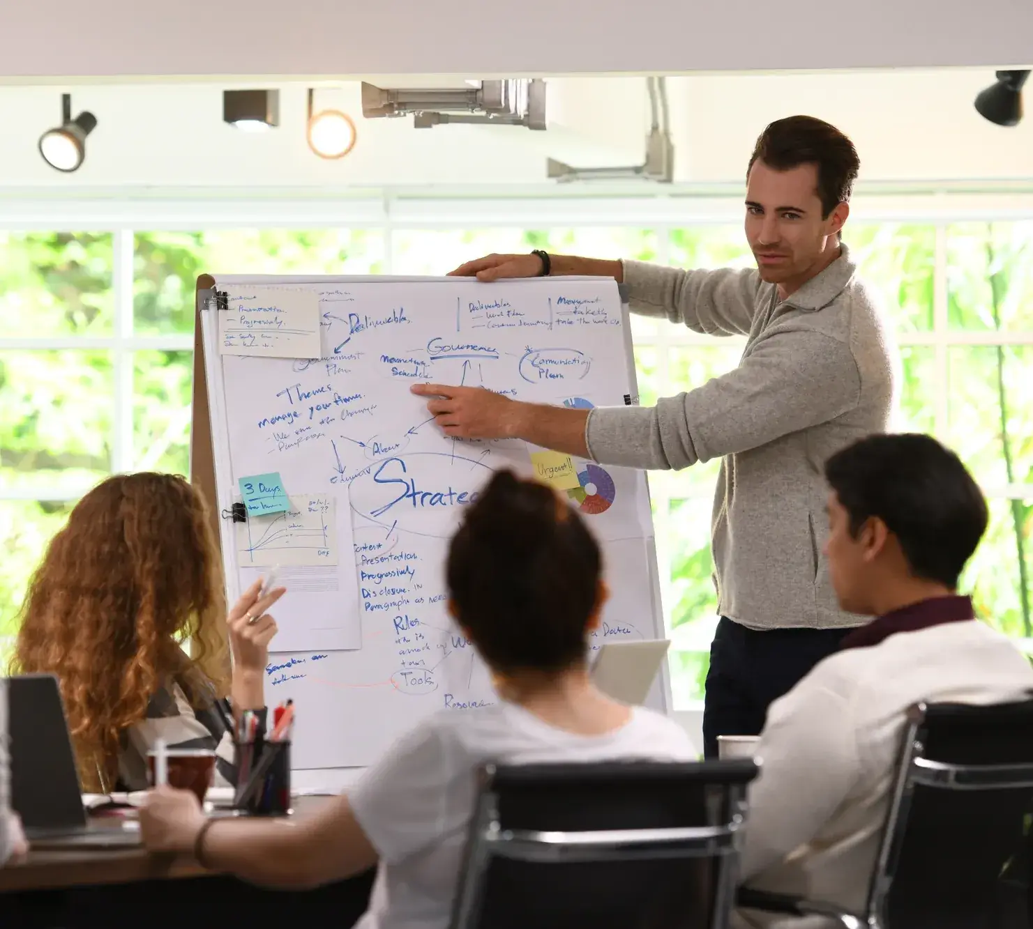 HR-manager licht de keuze toe aan het team bij de flipchart