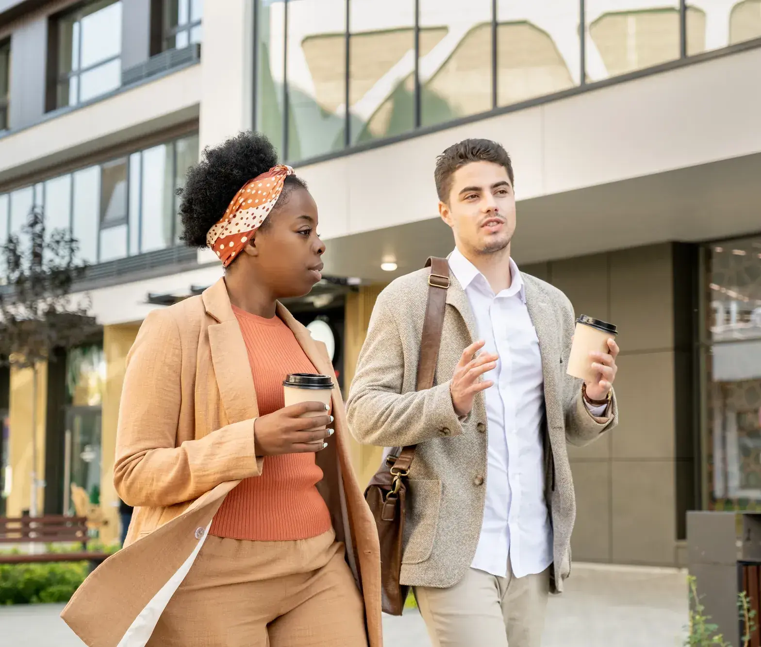 Manager en medewerker houden hun bila wandelend met een koffie