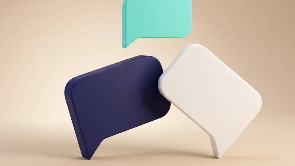 Een donkerblauwe en een witte Dialog-spreekwolk die rustig tegen elkaar leunen, met een kleine turquoise wolk erboven, op beige