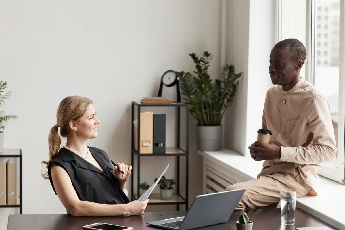 Collega’s in gesprek tijdens een pauze bij het raam