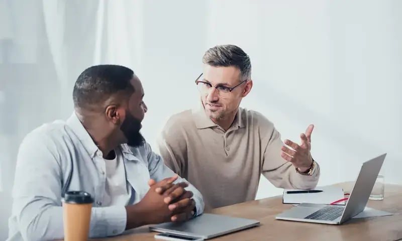 Twee collega’s overleggen aan een laptop