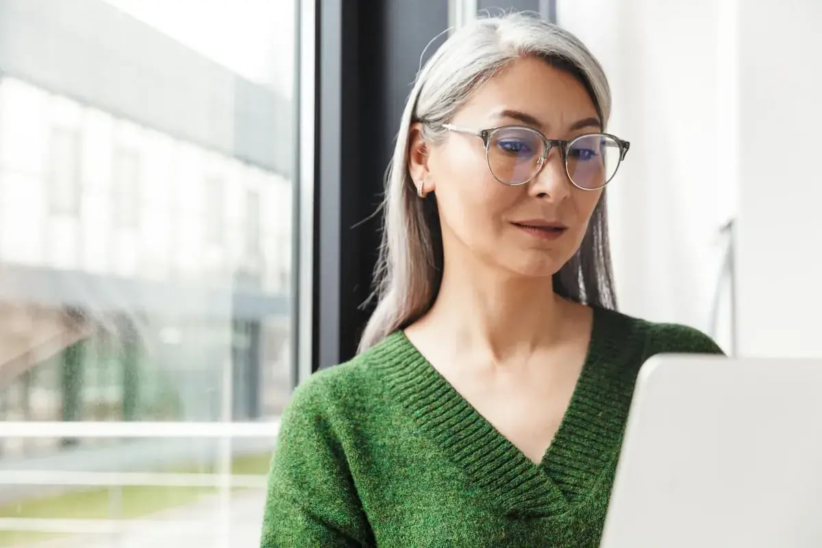 Een medewerker werkt geconcentreerd achter haar laptop