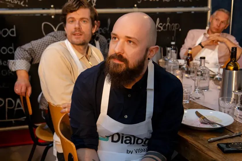 Collega’s in Dialog-schorten aan tafel