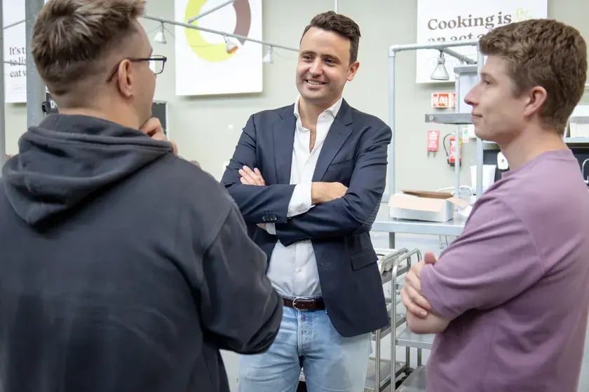 Drie collega’s in gesprek in een kookstudio