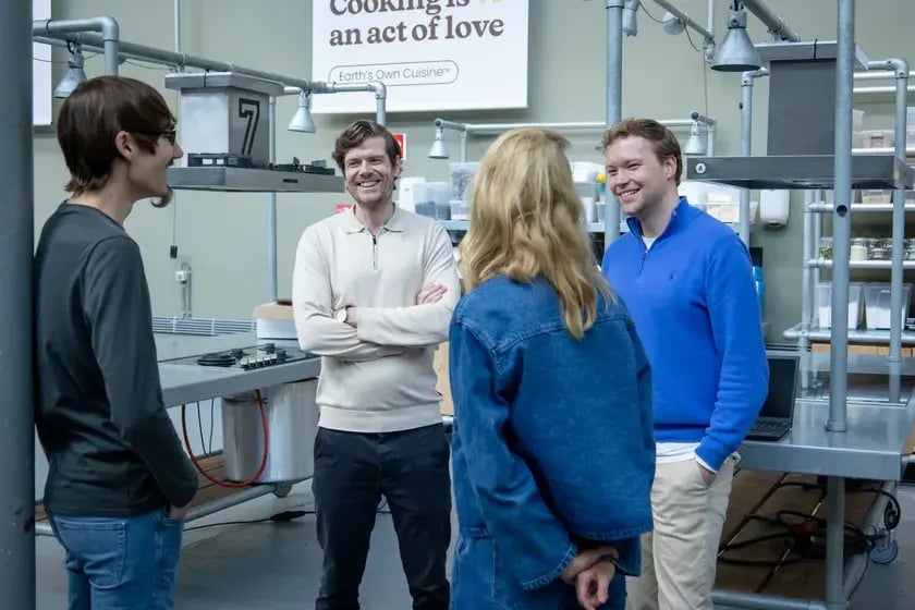 Vier collega’s in gesprek in een kookstudio