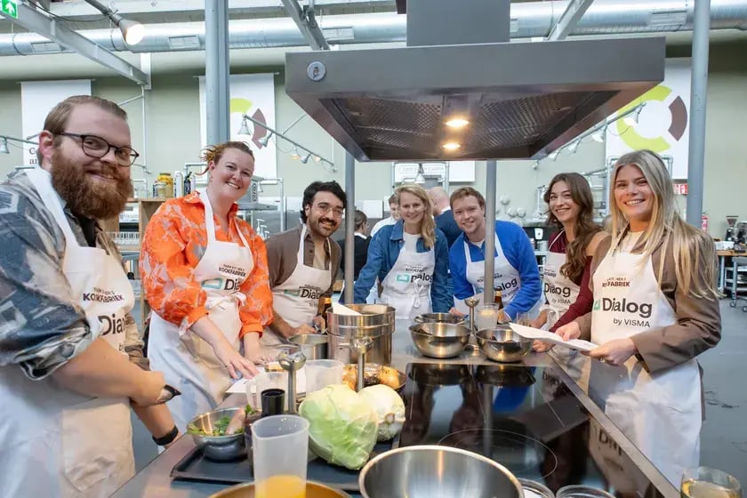 Collega’s in Dialog-schorten koken samen