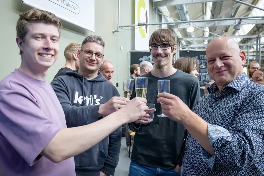 Vier collega’s proosten met een glas