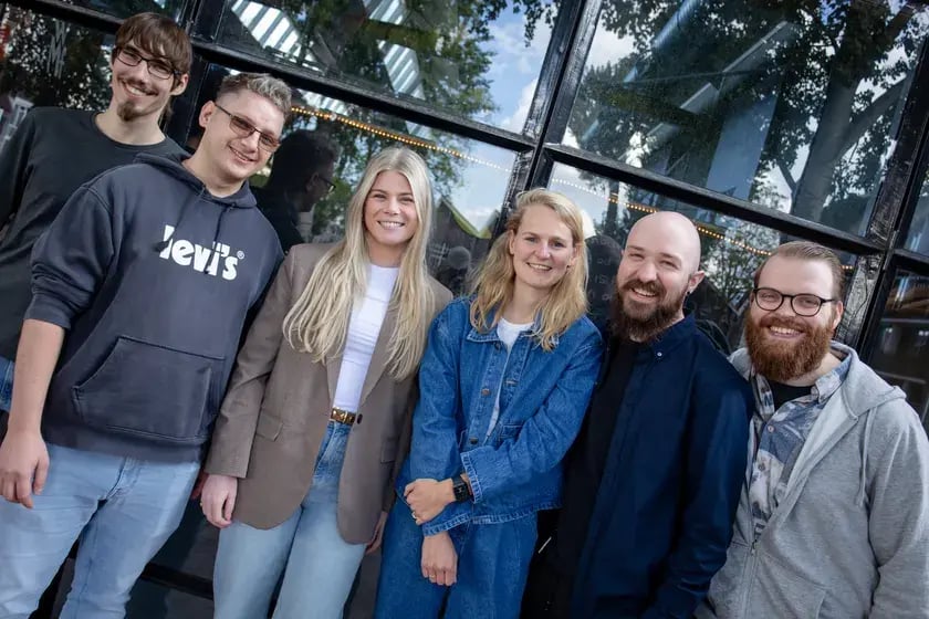 Zes collega’s lachen samen in de camera