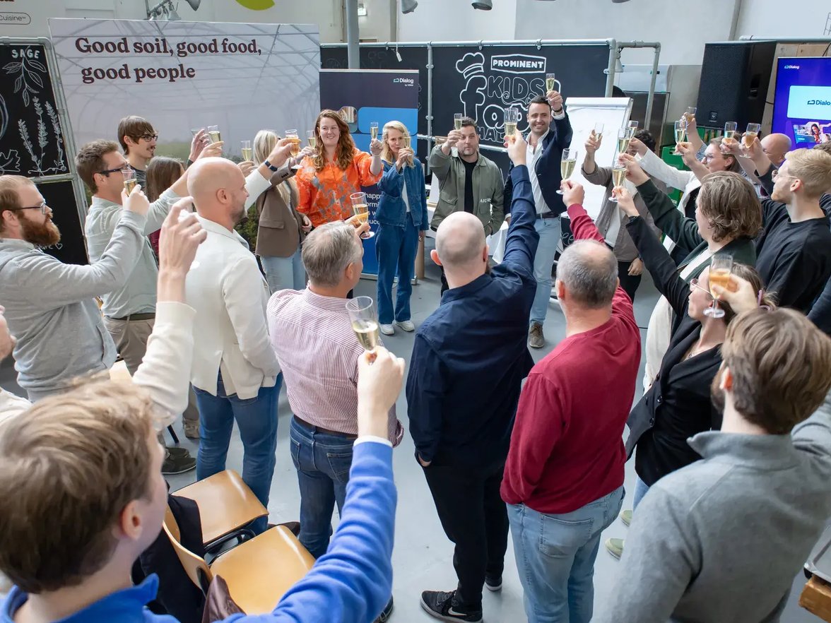 Collega’s heffen samen het glas tijdens een bedrijfsuitje