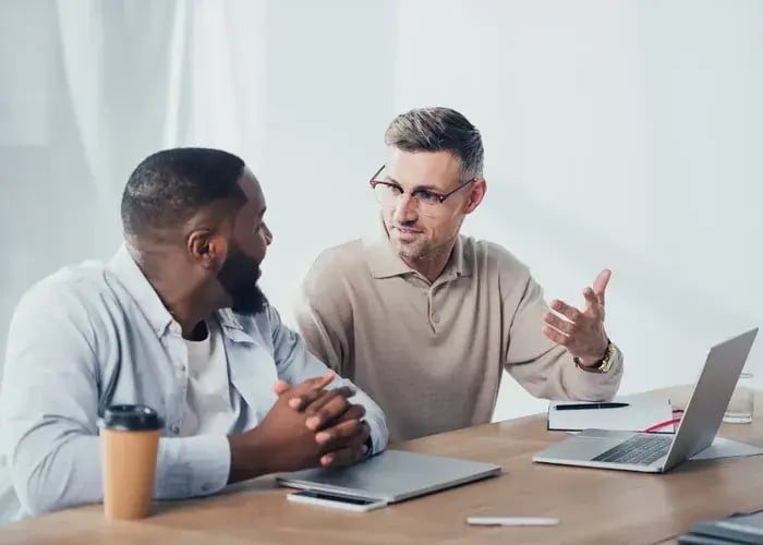 Twee collega's overleggen bij een laptop