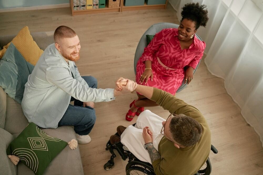 young-caucasian-man-greeting-young-man-with-disabi-2025-06-17-22-45-48-utc